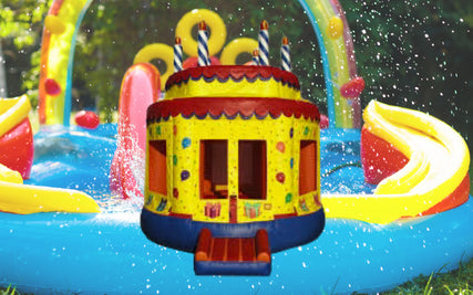 Party & Event RentalsA girl going down a inflatable water slide, with a bounce house in front of the image